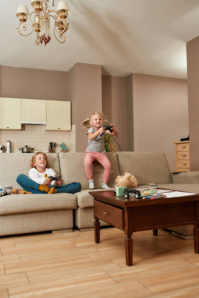 istock Joyful little children, boy and girl looking focused while playing video games using game controllers at home 1293456843