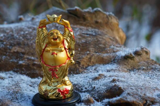 istock Buddha figurine on a wooden background covered with fine snow. 1293458428