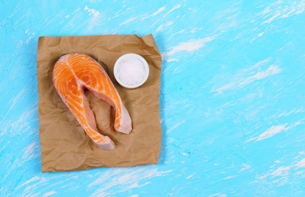 istock Raw salmon steaks on a blue stone background. flat lay. copyspace 1293458762