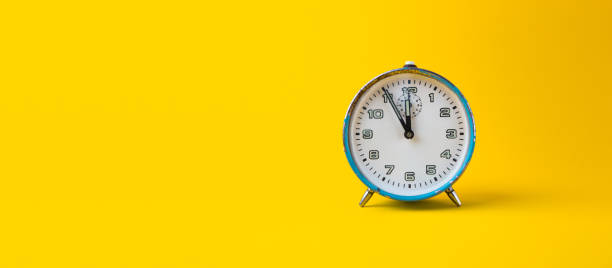 istock Old blue analog clock on a yellow background. It's 11.55 o'clock. New year. 1293459701