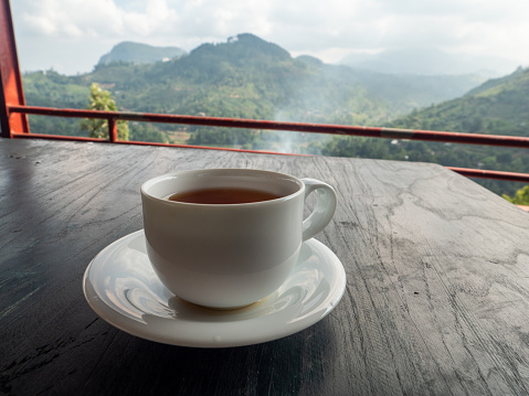 Tea cup on table above tea plantations in Sri Lanka