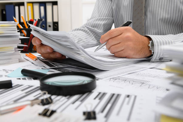 istock business concept - businessman working with reports in office, table and workspace close view, analyzing financial data, writes and counts 1293462580