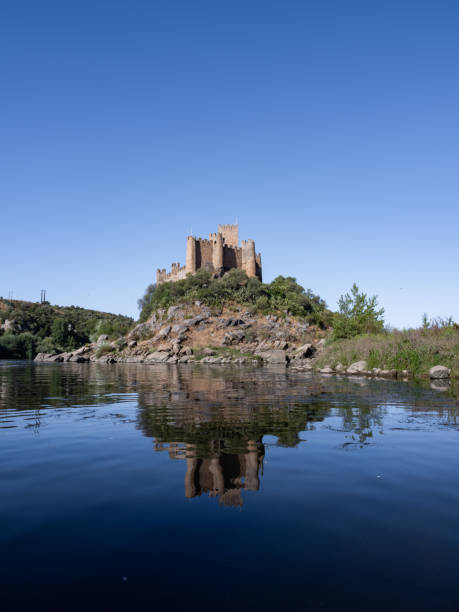 il castello di almourol e il suo riflesso nell'acqua del fiume tejo, in portogallo. - almourol foto e immagini stock