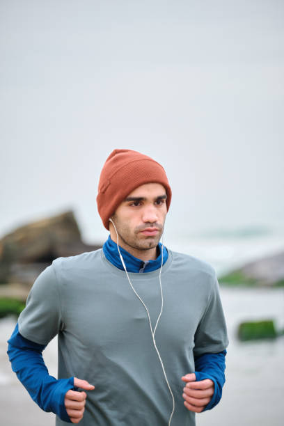 istock 20-24 years old men running at coastline on cold temperature 1293469911