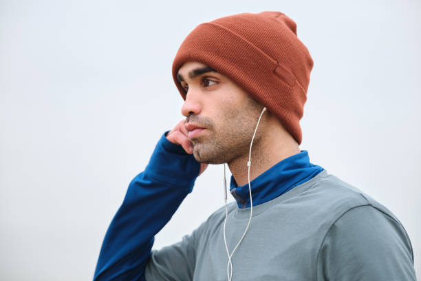 20-24 years old men running at coastline on cold temperature