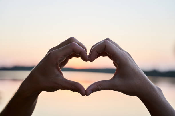 istock Couple in love gesturing heart 1293470178