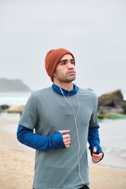 istock 20-24 years old men running at coastline on cold temperature 1293470191