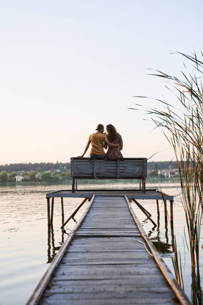 istock Couple sitting on a wooden bridge 1293470234