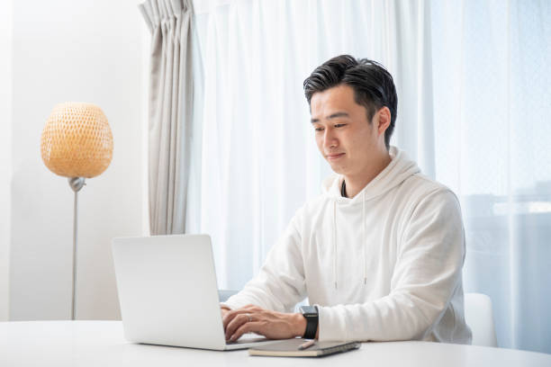 istock Young man working on a computer in the living room 1293472092