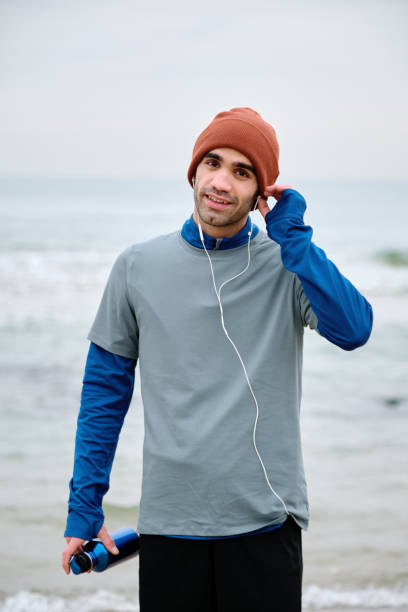 istock 20-24 years old men training at coastline on cold temperature 1293472395
