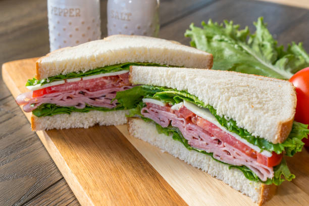 istock Ham and cheese sandwhich on cutting board 1293475053