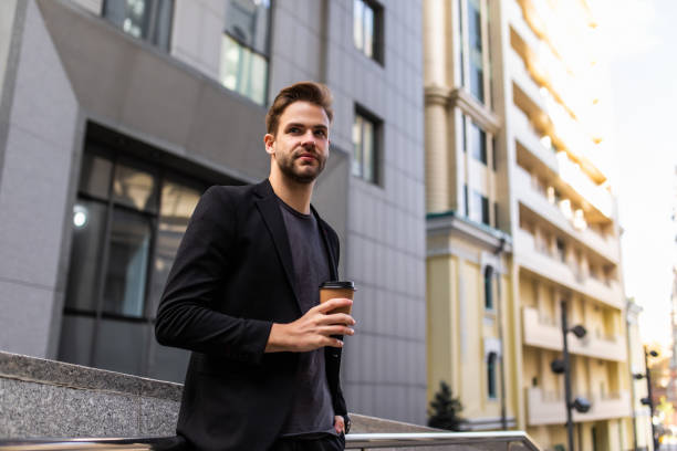 istock Elegant young businessman with take-out coffee going to work 1293477700
