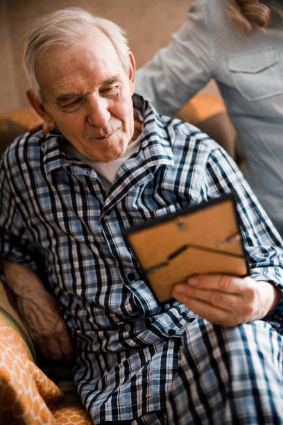 istock Elderly man looking at the photo in the frame 1293481198