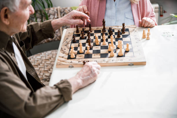 istock Elderly couple playing chess at home 1293483413