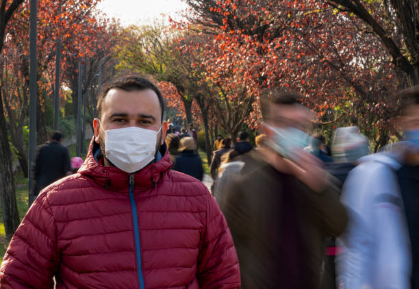 istock Man wearing protective mask smiling in crowd 1293487685
