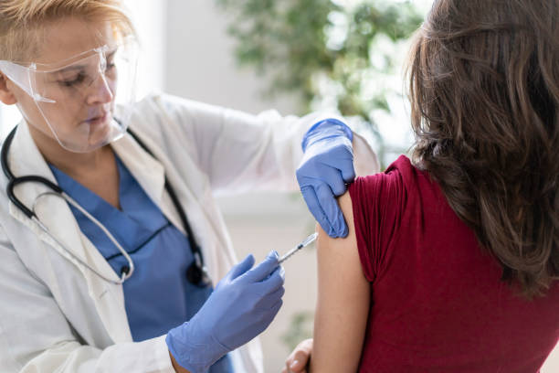 istock Vaccinating a young woman in doctors's office 1293487746