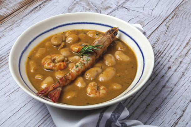 Homemade White Bean Stew with Prawns Traditional Homemade White Bean Stew with Prawns. Typical Spanish food. on wooden background fabes stock pictures, royalty-free photos & images