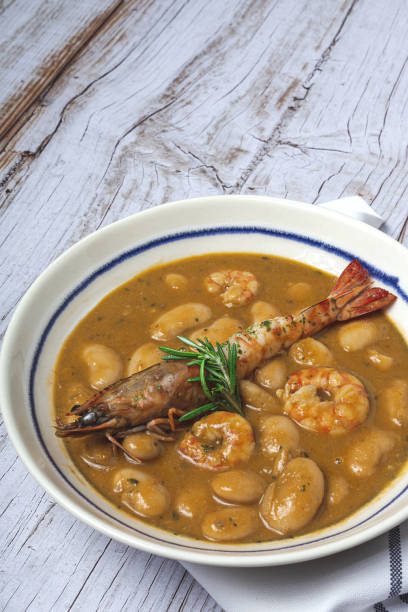 Homemade White Bean Stew with Prawns Traditional Homemade White Bean Stew with Prawns. Typical Spanish food. on wooden background fabes stock pictures, royalty-free photos & images
