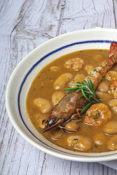 Homemade White Bean Stew with Prawns Traditional Homemade White Bean Stew with Prawns. Typical Spanish food. on wooden background fabes stock pictures, royalty-free photos & images