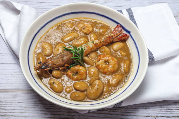 Homemade White Bean Stew with Prawns Traditional Homemade White Bean Stew with Prawns. Typical Spanish food. on wooden background fabes stock pictures, royalty-free photos & images