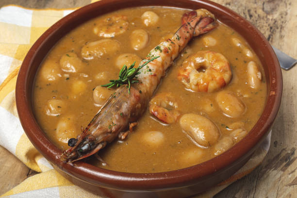 Homemade White Bean Stew with Prawns Traditional Homemade White Bean Stew with Prawns. Typical Spanish food. on wooden background fabes stock pictures, royalty-free photos & images