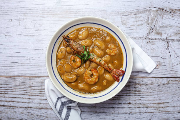 Homemade White Bean Stew with Prawns Traditional Homemade White Bean Stew with Prawns. Typical Spanish food. on wooden background fabes stock pictures, royalty-free photos & images