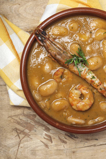 Homemade White Bean Stew with Prawns Traditional Homemade White Bean Stew with Prawns. Typical Spanish food. on wooden background fabes stock pictures, royalty-free photos & images