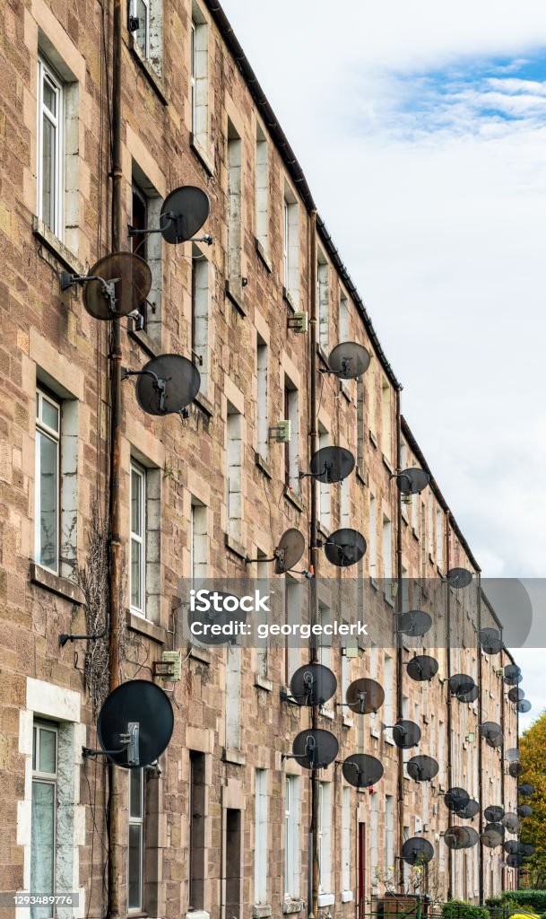 Satellite dishes outside residential flats A large number of satellite dishes on the exterior of a tenement block in Dundee, Scotland. Scotland Stock Photo