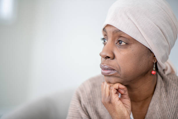 Worried about a cancer relapse A portrait of a worried female African American cancer patient looking away as she is deep in her thoughts. cancer illness stock pictures, royalty-free photos & images