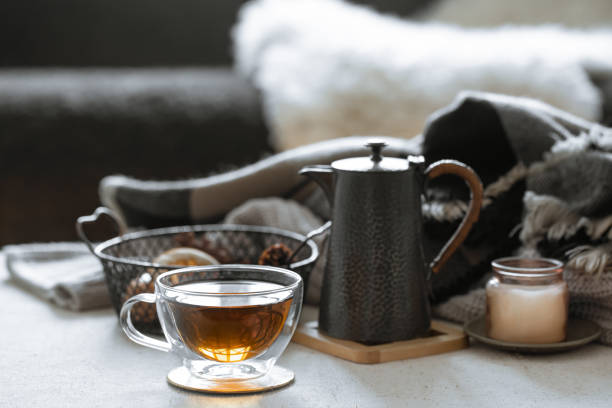 istock Cozy home composition with a cup of tea, kettle and candlestick close up. 1293493939