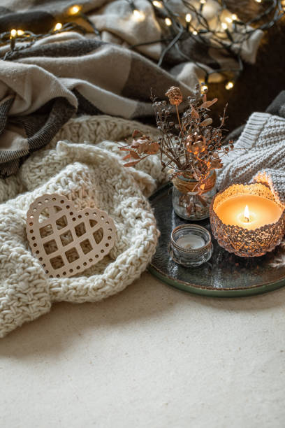 istock Cozy home composition with a burning candle and knitted elements. 1293493951