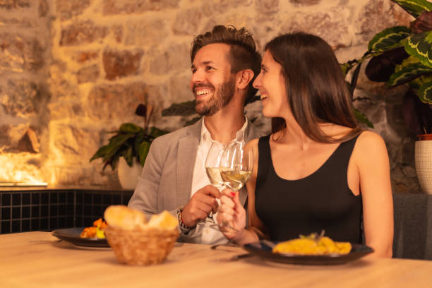 istock Lifestyle, a young European couple toasting drinks while having dinner in a restaurant, celebrating Valentine's 1293494758