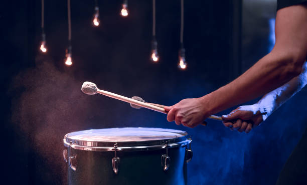 istock The drummer plays with mallets on floor tom in dark room. 1293494951