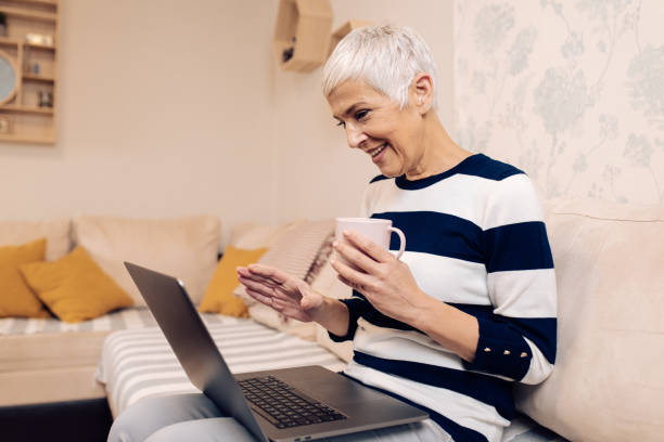 istock Mature woman making a video call on her laptop 1293495110