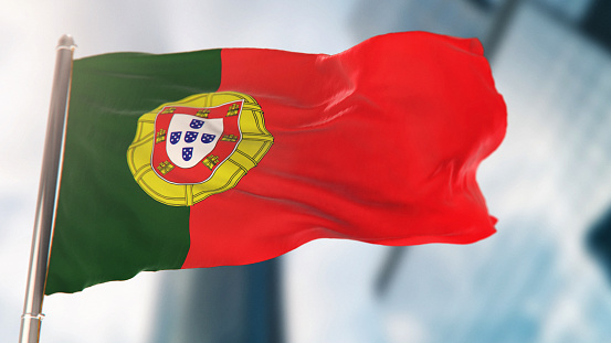 National Flag of Portugal Against Defocused City Buildings