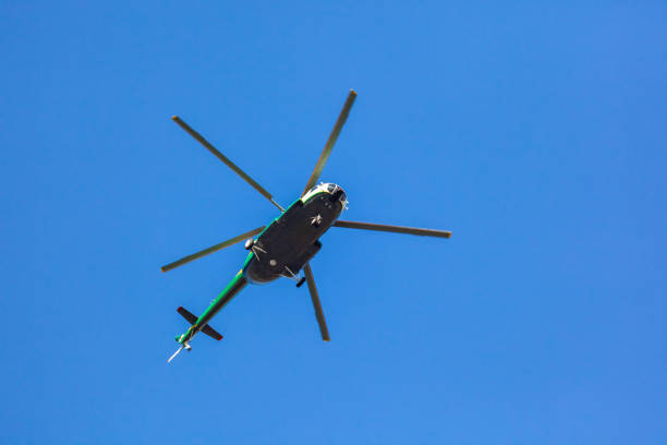 Helicopter flying against the blue sky, rotary wing aircraft flying to transport