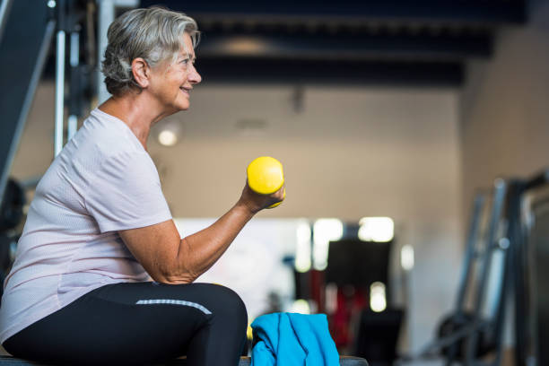 coppia di due anziani felici e in forma che fanno esercizio in palestra insieme correndo sul tapis roulant - stile di vita attivo - women weight bench exercising weightlifting foto e immagini stock