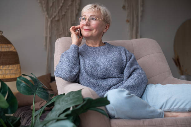 istock Senior woman talking on mobile phone at home 1293501115