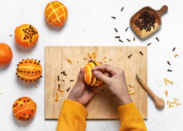 Top view of girl's hands making cloves ornaments onto an orange for Christmas decoration. Top view of girl's hands making cloves ornaments onto an orange for Christmas decoration. Step 3. scent container stock pictures, royalty-free photos & images