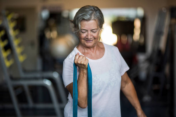 coppia di due anziani felici e in forma che fanno esercizio in palestra insieme correndo sul tapis roulant - stile di vita attivo - women weight bench exercising weightlifting foto e immagini stock