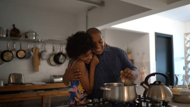 istock Father and daughter embracing while cooking at home 1293504088