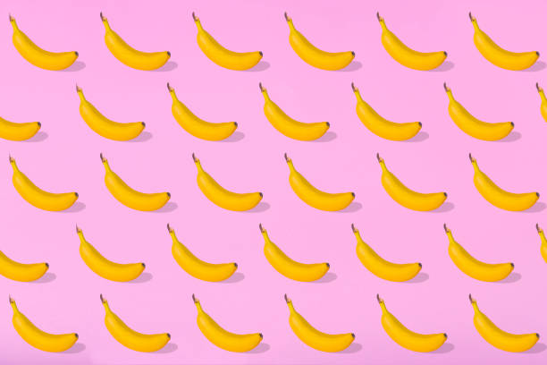 istock Trendy Summer pattern made with fresh banana fruit on bright light pink background 1293504707