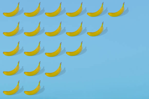 istock Trendy Summer pattern with fresh banana fruit on bright light blue background 1293504712