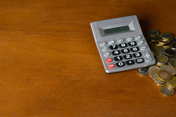 electronic calculator with coins - argentina mexican pesos currency finance imagens e fotografias de stock