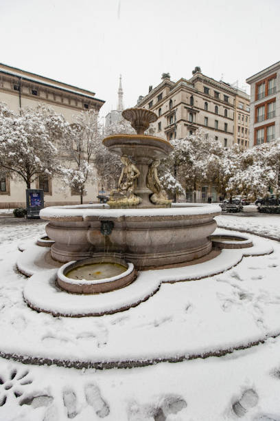 Milan, Italy - December 28, 2020: street view of Milan during the snow blizzard of late December, people are visible in the distance.
