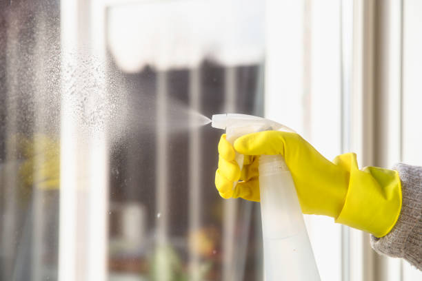 istock Cleaning a window with spray detergent, Yellow rubber gloves and dish cloth on work surface concept for hygiene, business and health concept 1293510897