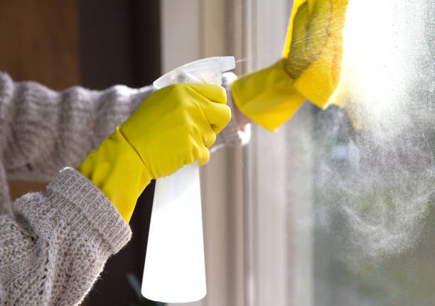 istock Cleaning a window with spray detergent, Yellow rubber gloves and dish cloth on work surface concept for hygiene, business and health concept 1293511162