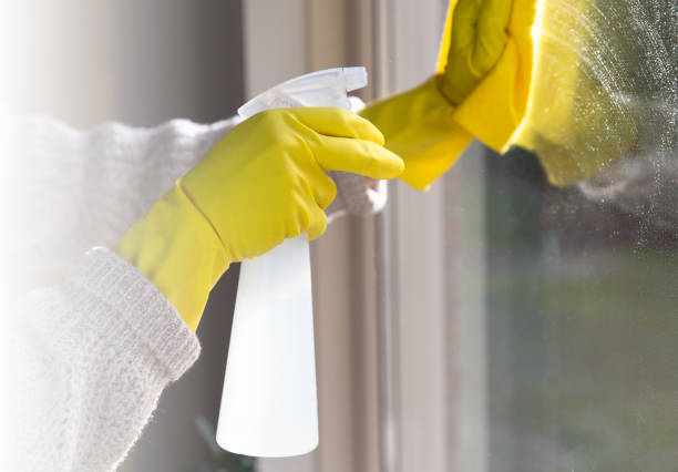 istock Cleaning a window with spray detergent, Yellow rubber gloves and dish cloth on work surface concept for hygiene, business and health concept 1293511220