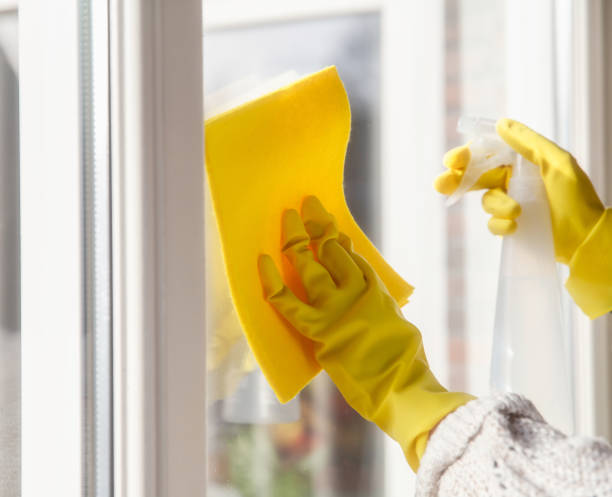 istock Cleaning a window with spray detergent, Yellow rubber gloves and dish cloth on work surface concept for hygiene, business and health concept 1293511805