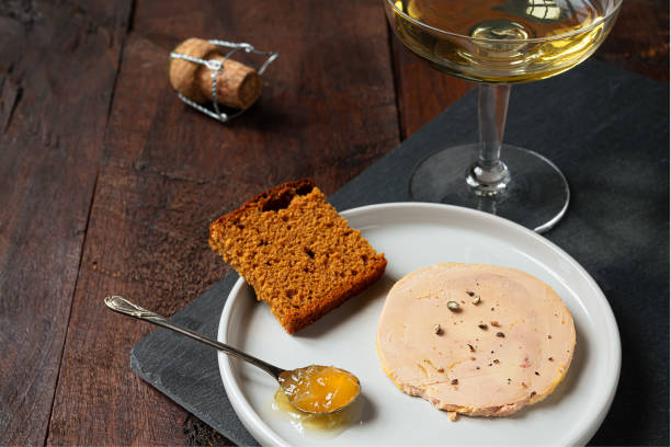 Foie gras and champagne Traditional French foie gras, gingerbread, candied onion in the teaspoon and a glass of champagne on the dark table foie gras stock pictures, royalty-free photos & images